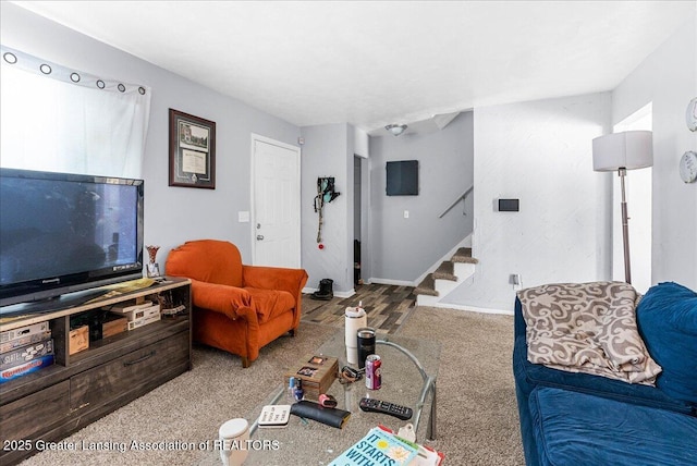 living room featuring stairs, carpet floors, and baseboards