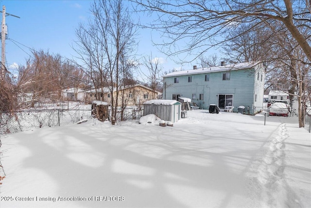 snow covered back of property with fence