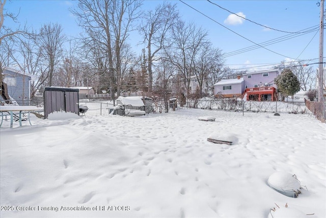 yard covered in snow featuring fence