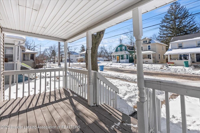 snow covered deck featuring a residential view