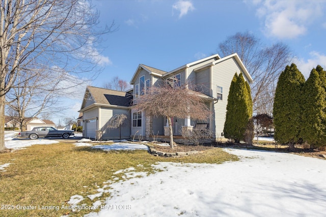 view of snowy exterior with a garage and a yard