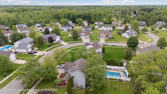 11610 Hibiscus Ln, Grand Ledge, MI 48837 - aerial perspective of suburban area with a pool and a heavily wooded area