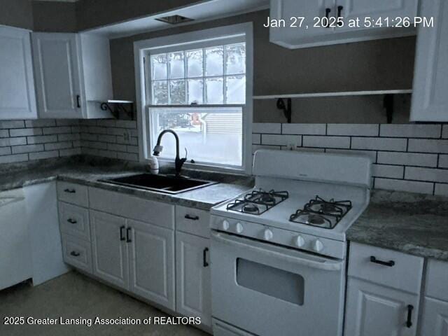 kitchen with open shelves, tasteful backsplash, white cabinetry, white range with gas cooktop, and a sink