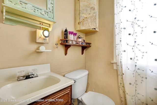 bathroom with toilet, curtained shower, and vanity