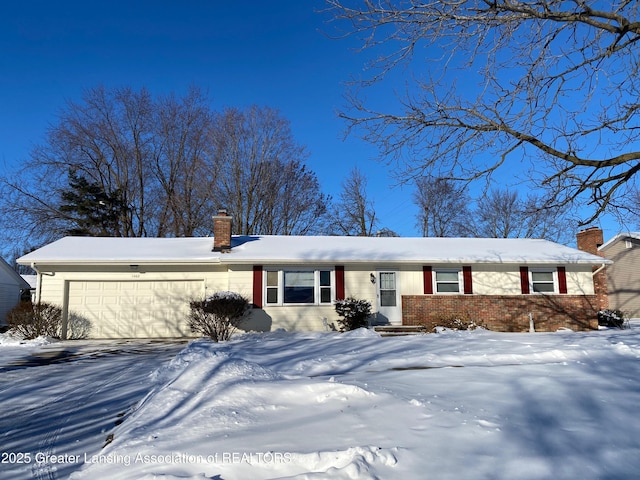 view of front facade with a garage, a chimney, aphalt driveway, and brick siding