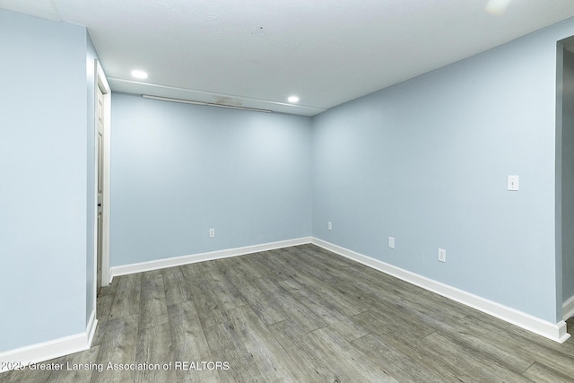 spare room with baseboards, wood finished floors, and recessed lighting