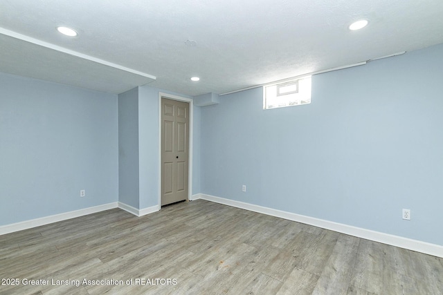 below grade area featuring light wood-style floors, baseboards, and recessed lighting