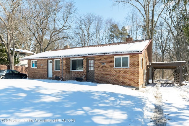 view of front facade featuring a carport, brick siding, and a chimney