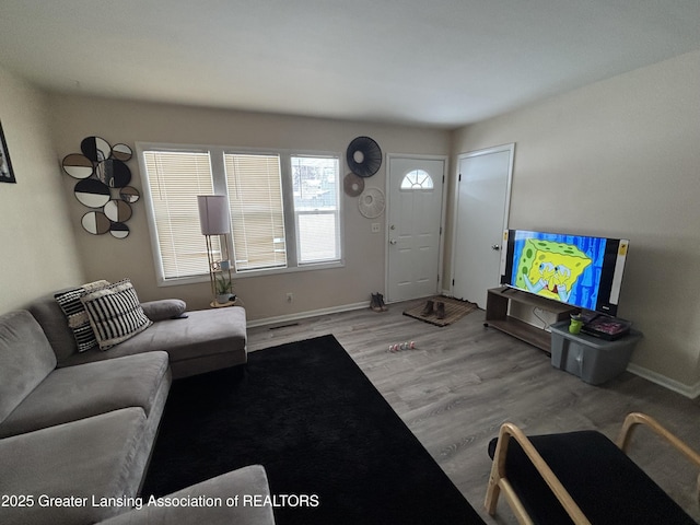 living room with visible vents, light wood-style flooring, and baseboards