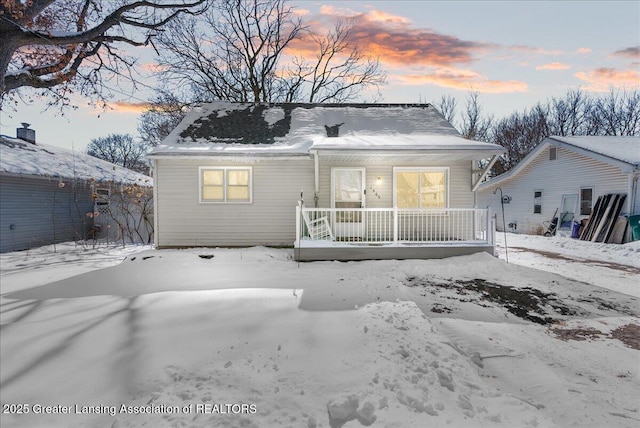 snow covered property with covered porch