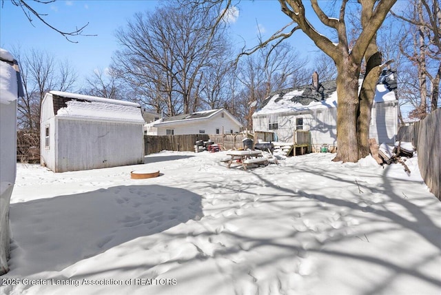 yard layered in snow featuring fence