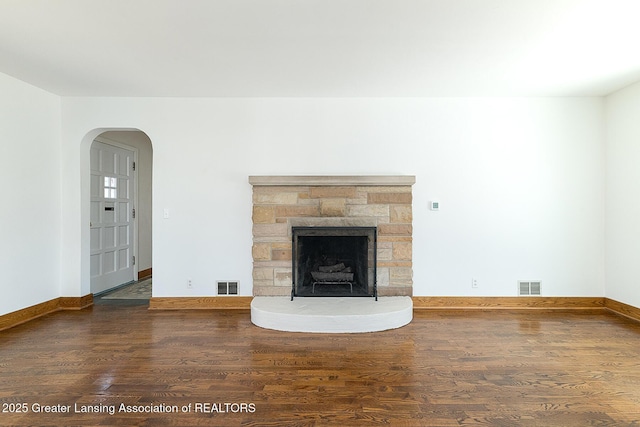 unfurnished living room with visible vents, baseboards, and wood finished floors