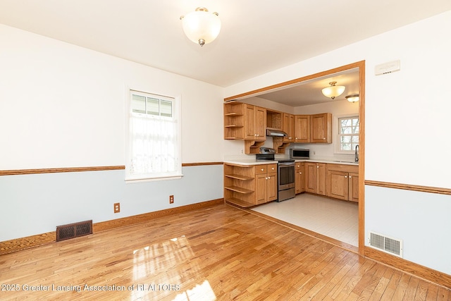 kitchen featuring open shelves, visible vents, appliances with stainless steel finishes, and under cabinet range hood