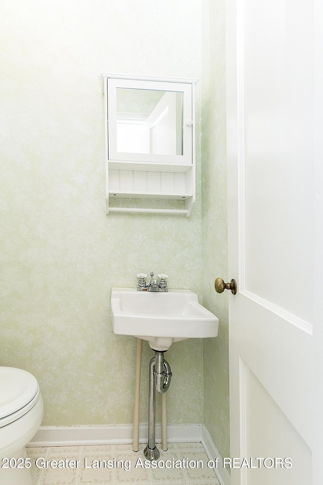 bathroom with baseboards and toilet