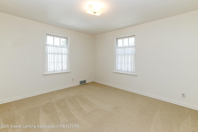 empty room with visible vents, baseboards, and carpet floors