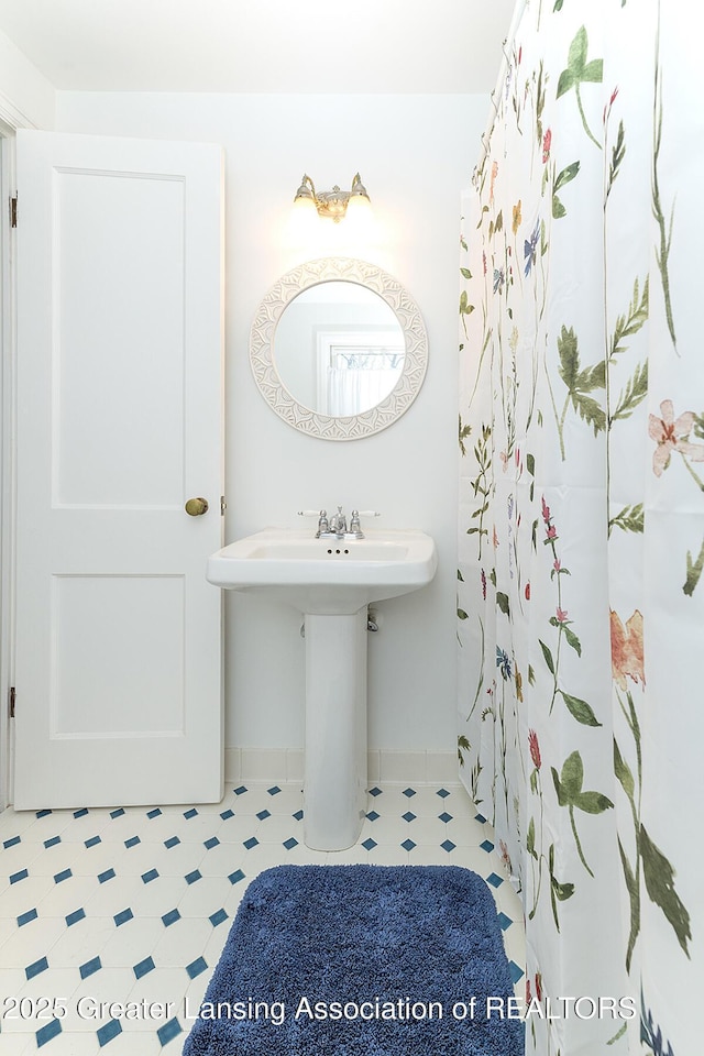 bathroom with tile patterned floors, baseboards, and a sink