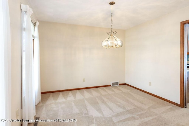 unfurnished room featuring light colored carpet, visible vents, and baseboards