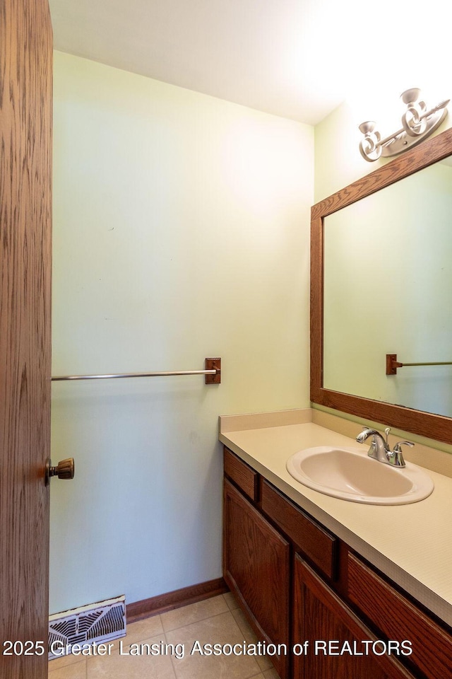 bathroom featuring baseboards, vanity, visible vents, and tile patterned floors