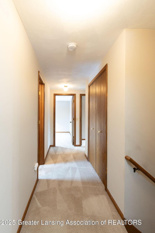 hallway with light carpet and baseboards