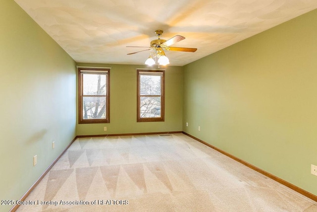 empty room with light carpet, ceiling fan, and baseboards