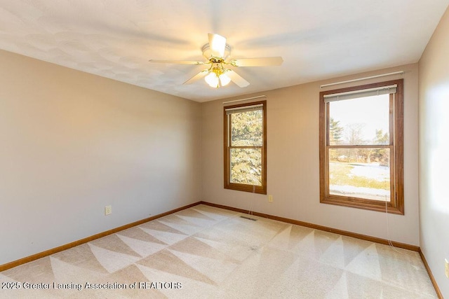 unfurnished room featuring visible vents, baseboards, a ceiling fan, and light colored carpet