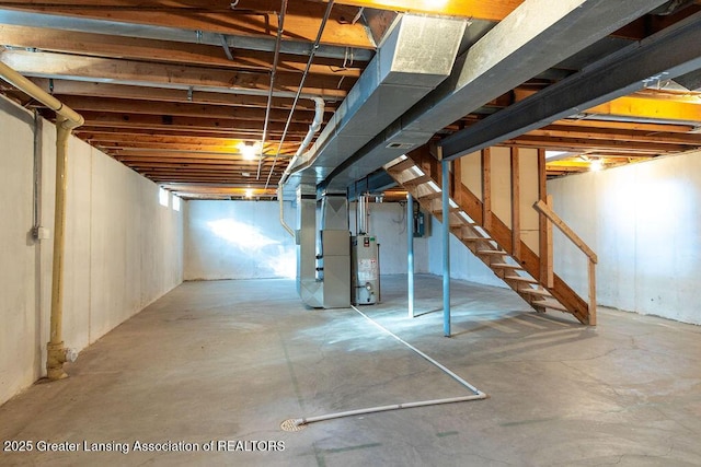 unfinished below grade area featuring heating unit, stairway, and gas water heater