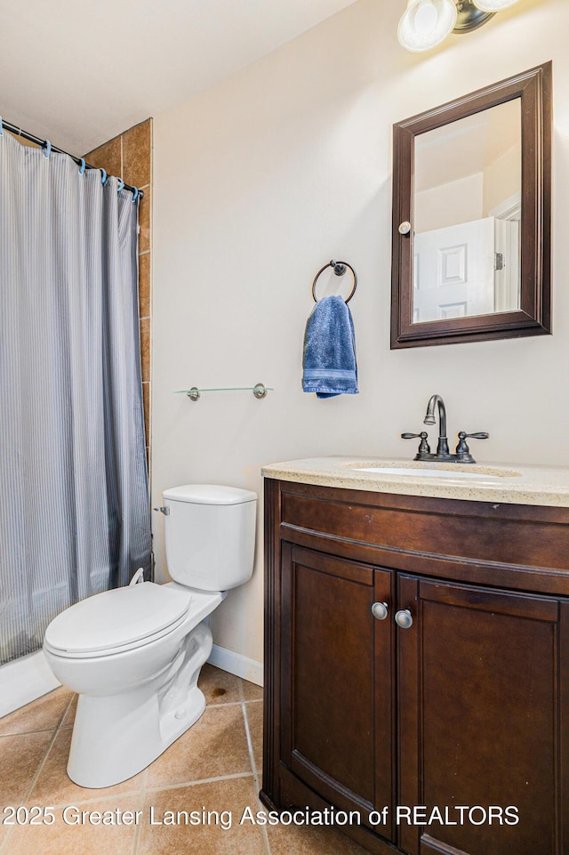 bathroom featuring baseboards, vanity, toilet, and tile patterned floors