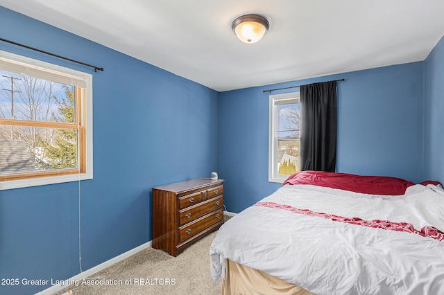 bedroom with light carpet and baseboards