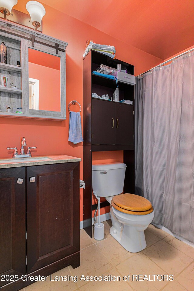 full bathroom featuring vanity, toilet, and baseboards