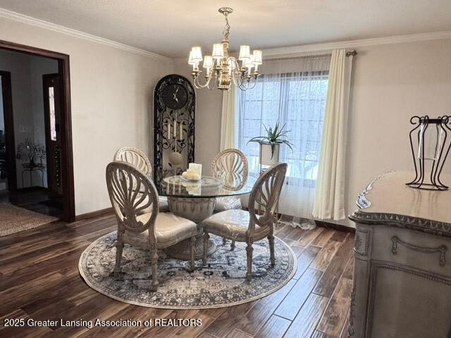 dining room featuring crown molding, a chandelier, dark wood finished floors, and baseboards