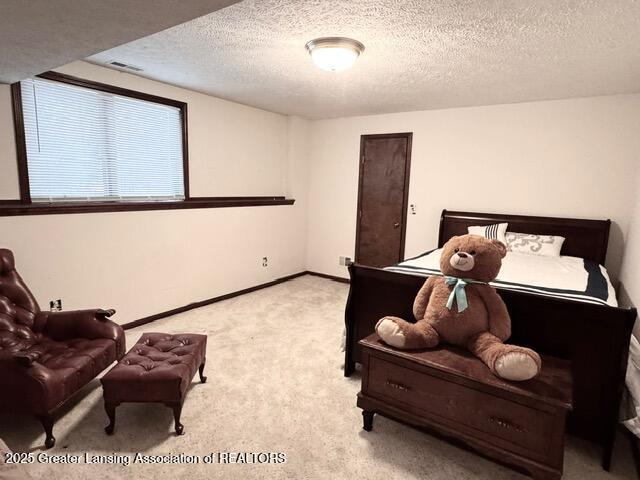 bedroom with carpet floors, baseboards, visible vents, and a textured ceiling