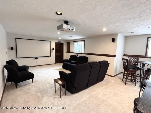 home theater room with a textured ceiling, recessed lighting, baseboards, and light colored carpet