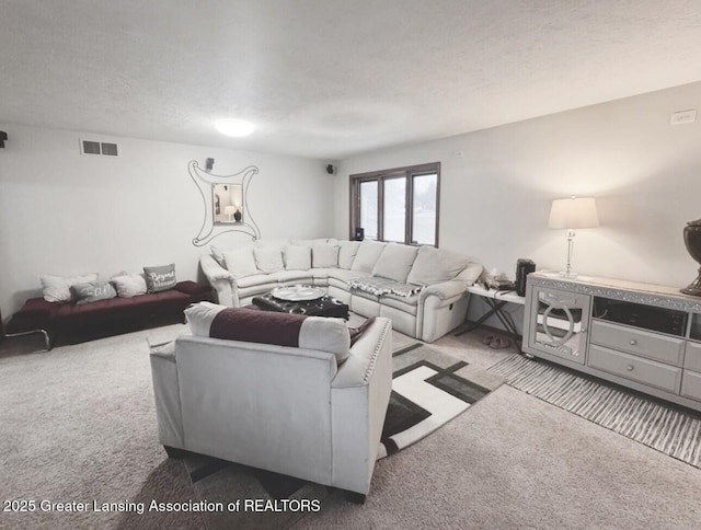 living room with carpet floors, visible vents, and a textured ceiling