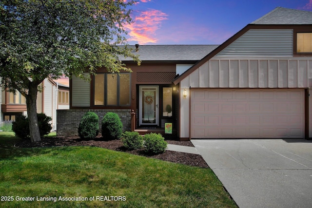 view of front facade featuring a garage, brick siding, driveway, board and batten siding, and a front yard