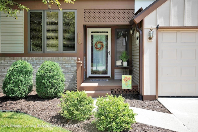 doorway to property with a garage and brick siding