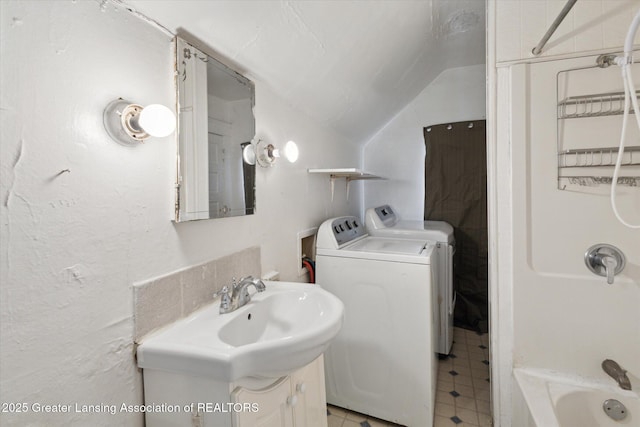 full bathroom with washer and dryer, shower / bath combination, a sink, and lofted ceiling