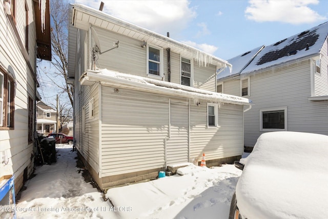 view of snow covered back of property