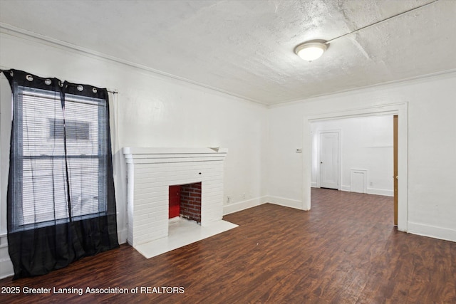 unfurnished living room featuring a brick fireplace, a textured ceiling, ornamental molding, and dark wood-type flooring