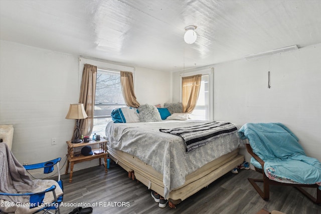 bedroom with dark wood-style flooring