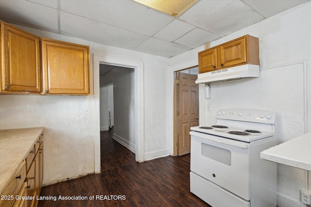 kitchen with dark wood-style flooring, light countertops, under cabinet range hood, and white electric range oven