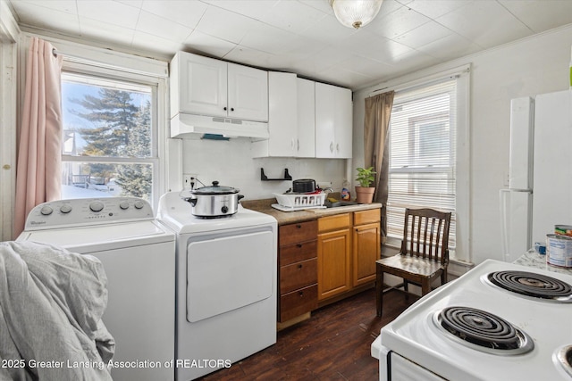 washroom with laundry area, dark wood-type flooring, separate washer and dryer, and a wealth of natural light