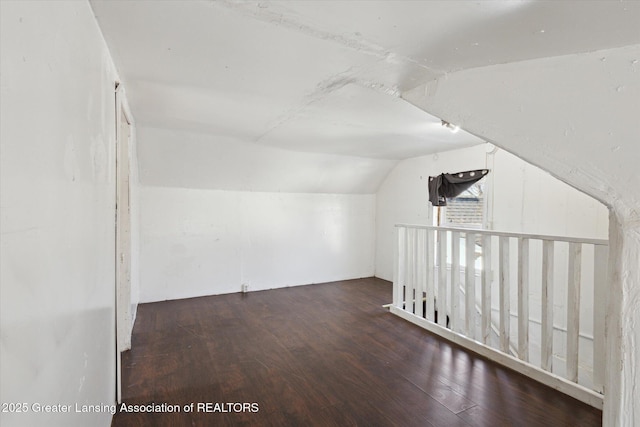 additional living space featuring dark wood-style floors and lofted ceiling