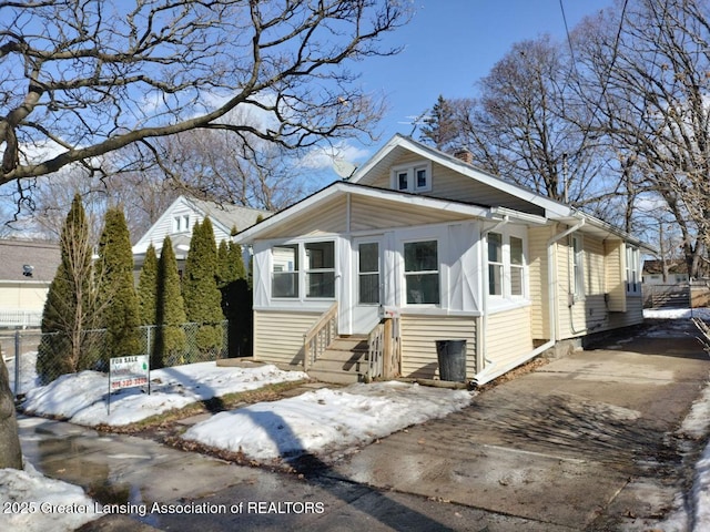 bungalow-style home featuring entry steps, fence, and driveway