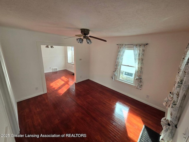 unfurnished bedroom with baseboards, visible vents, a ceiling fan, dark wood-style flooring, and a textured ceiling