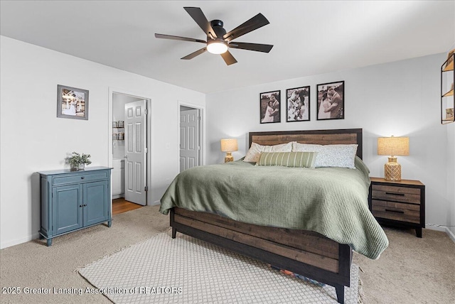 bedroom with light carpet, ensuite bath, a ceiling fan, and baseboards