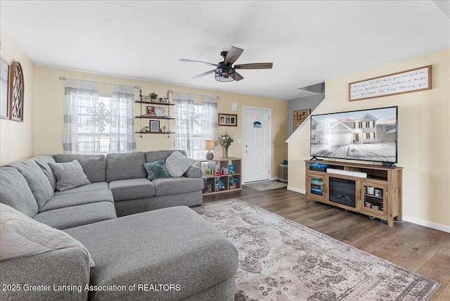 living room featuring ceiling fan, wood finished floors, and baseboards