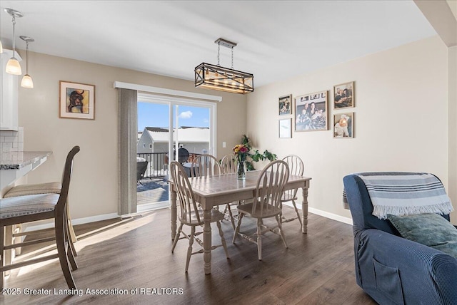 dining space featuring dark wood-style floors and baseboards