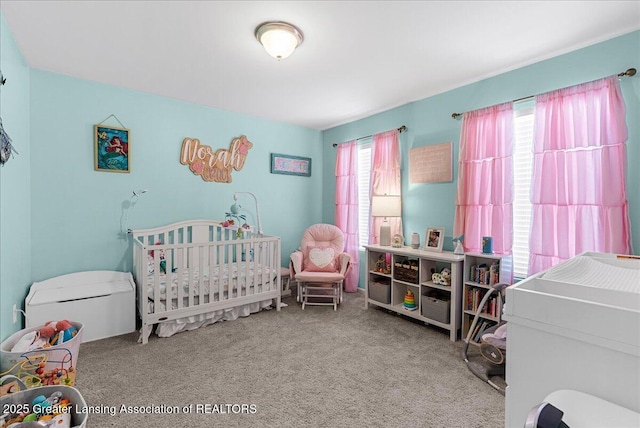 carpeted bedroom with a nursery area