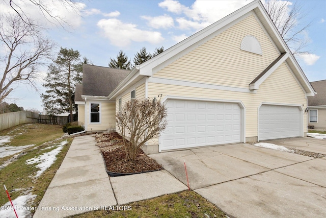 view of front of property featuring driveway and fence