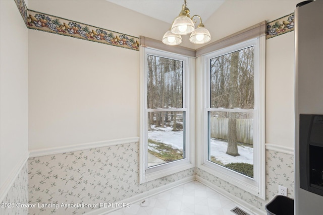 dining space with wallpapered walls, baseboards, visible vents, light floors, and a notable chandelier